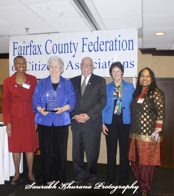 Kate Hanley holding her Lifetime Achievement Award with Hunter Mill Supervisor Cathy Hudgins, Representative Gerry Connolly, Board Chairman Sharon Bulova, and Federation President Tania Hossain